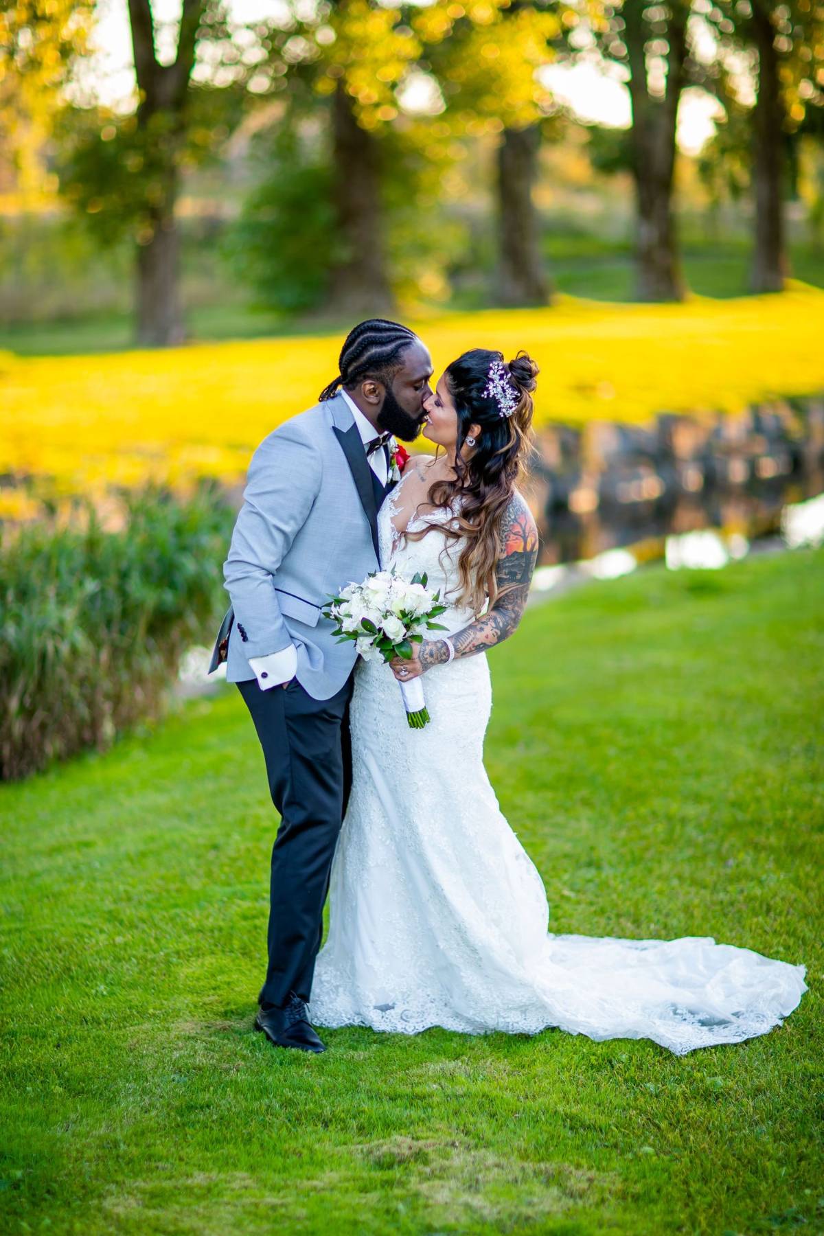 Bride and groom kissing by a pond, black and white